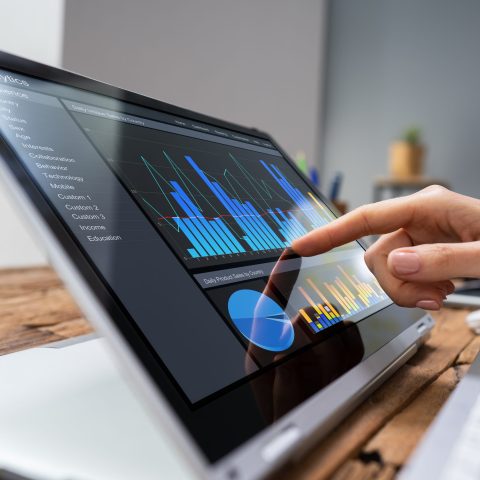 Zakelijke vrouw bestudeerd grafieken en tabellen op het beeldscherm