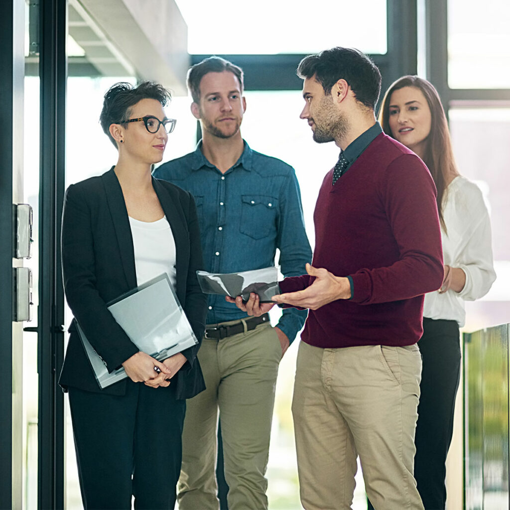 En CEO står sammen med tre kollegaer