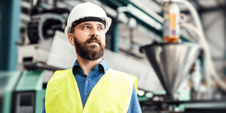 En mand med sikkerhedshjelm og en gul sikkerhedsvest