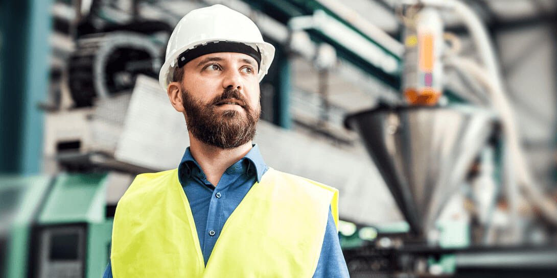 En mand med sikkerhedshjelm og en gul sikkerhedsvest